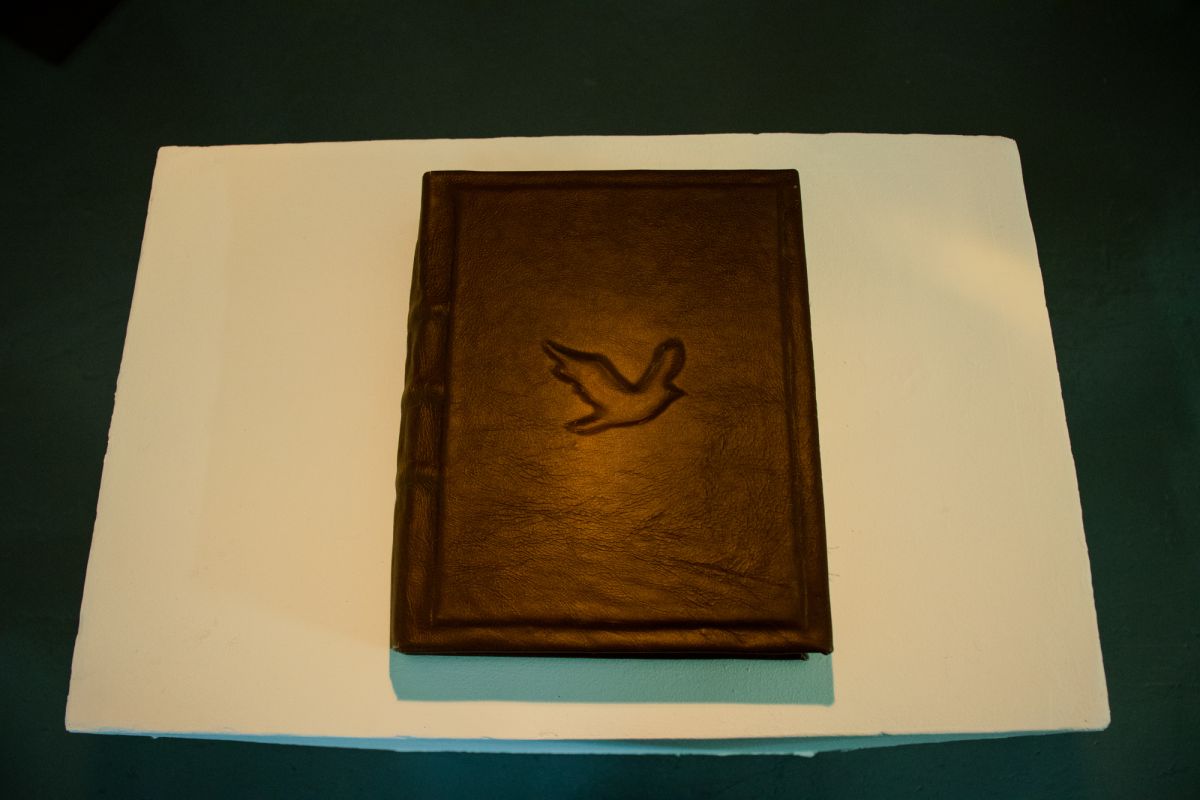 Hand-bound leather book. Documents the performative photo series, and includes tactile fabric samples used within the piece