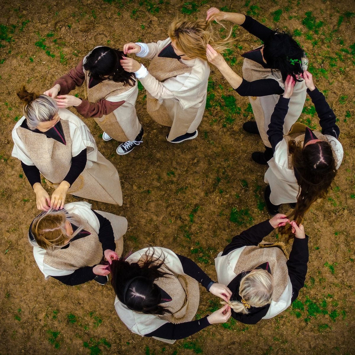 An infinite, interdependent circle where each woman braids another's hair
