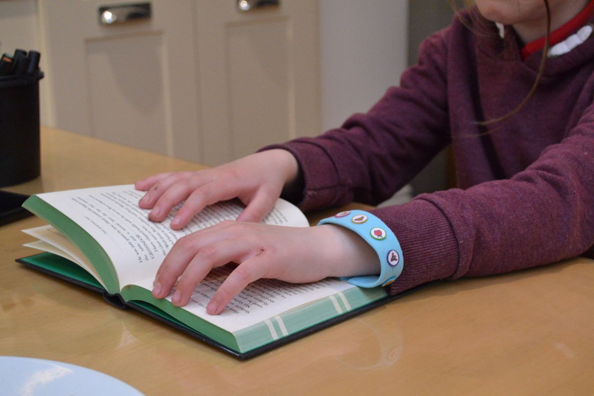 User wearing bracelet while reading