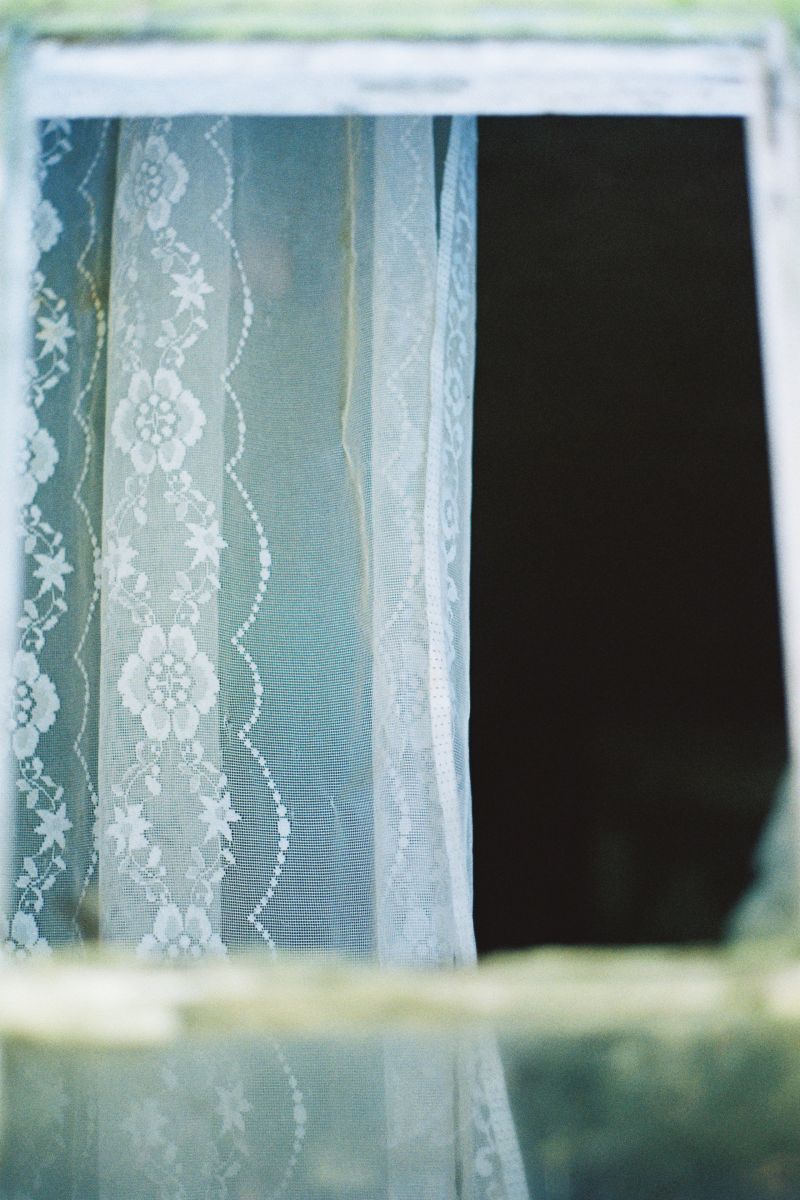Detail of a lace curtain in an abandoned house window taken by Rose Merriman in Co. Wicklow, 2019